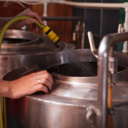A technician cleaning brewery equipment.